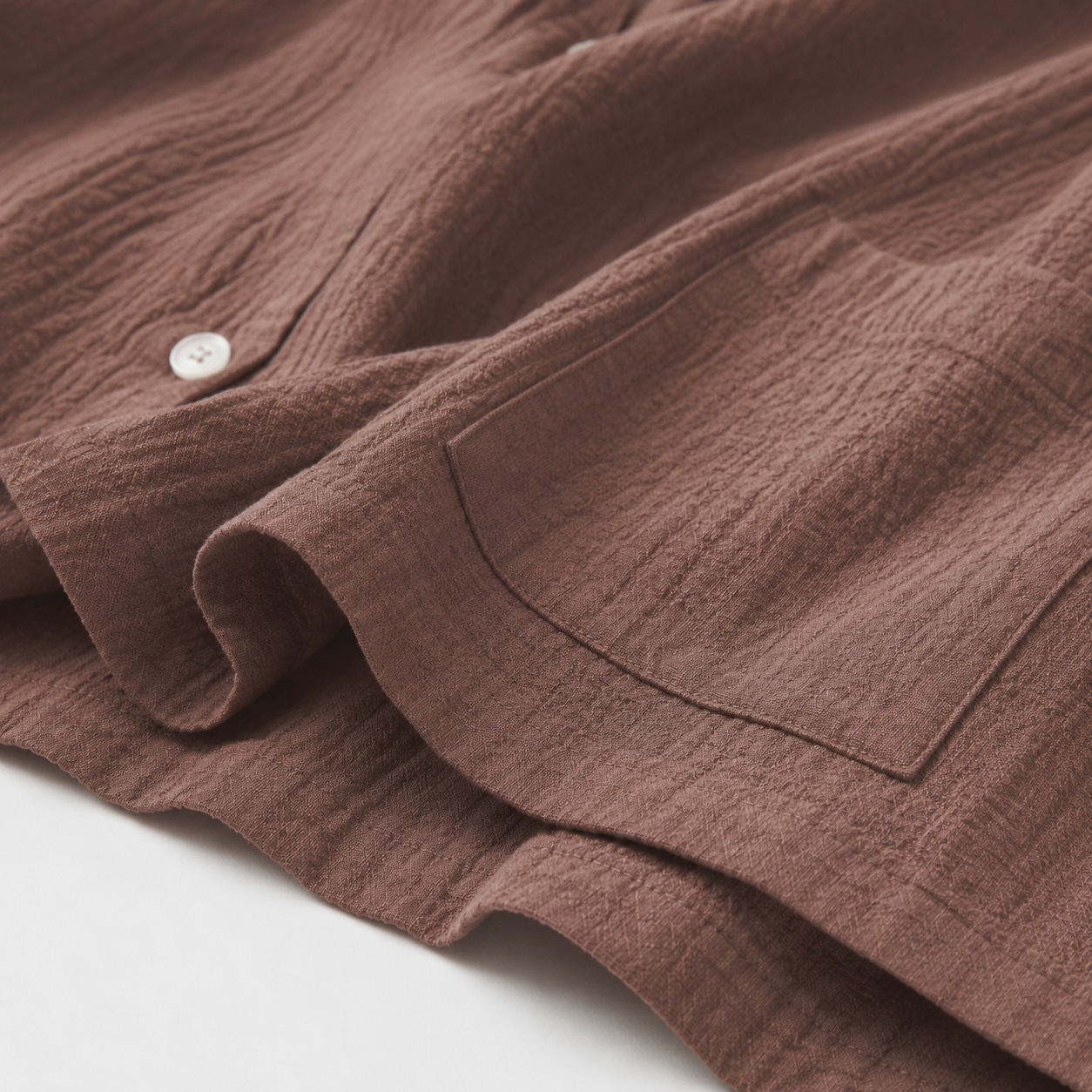 Premium mauve organic cotton muslin fabric texture and refined stitching detail