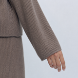 Taupe woolen knit sweater sleeve and cuff close-up